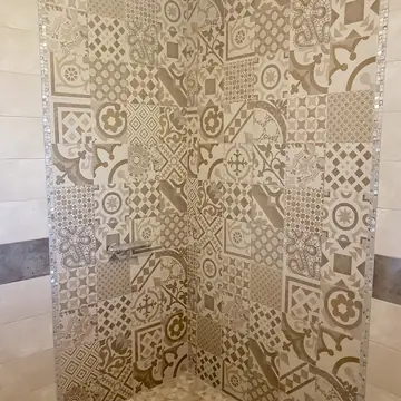 Douche avec mosaïque et revêtement carrelé réalisée par BMH Rénovation