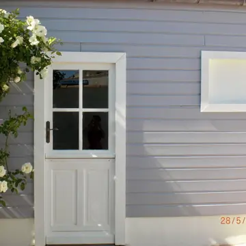 Finitions de peinture extérieure autour d’une porte et d’une fenêtre réalisées par BMH Rénovation