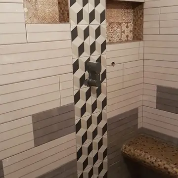 Salle de bain avec douche et murs carrelés réalisée par BMH Rénovation