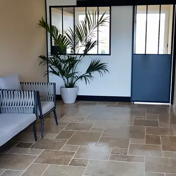 Pièce de vie avec vaste sol carrelé réalisée par BMH Rénovation